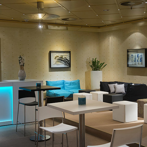 Moderne Lounge mit Sitzgelegenheiten und Bar im Maritim proArte Hotel Berlin, ideal für Meetings und Networking.