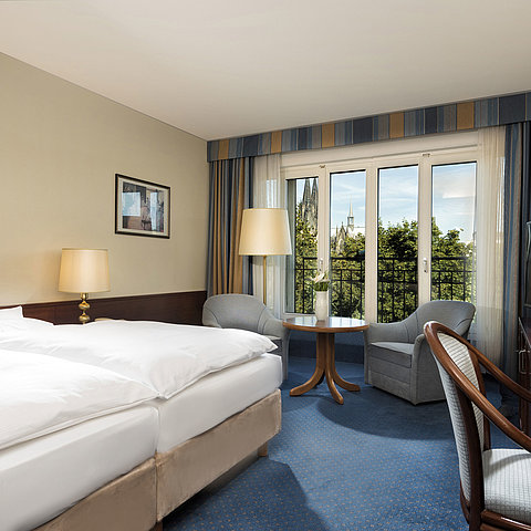 Superior-Doppelzimmer im Maritim Hotel Köln mit gemütlicher Einrichtung und Blick auf den Kölner Dom.