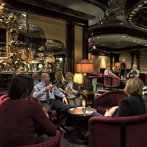 Gäste entspannen in der stilvollen Pianobar des Maritim Hotels Bonn bei Drinks und angenehmer Atmosphäre.
