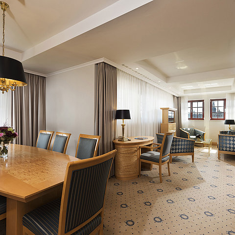 Geräumige Executive Suite im Maritim Hotel Dresden mit elegantem Esstisch, komfortabler Sitzecke und Blick auf die Stadt.