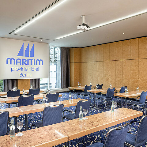 Konferenzraum im Maritim proArte Hotel Berlin mit Reihenbestuhlung und Projektionsfläche.