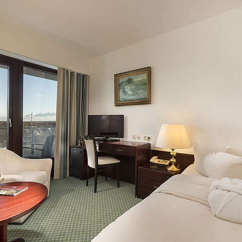 Helles Classic Zimmer im Maritim Seehotel Timmendorfer Strand mit Balkon, Schreibtisch und gemütlicher Sitzecke, Meerblick.