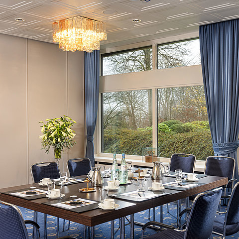 Salon Flensburg im Maritim Hotel Kiel, Konferenzraum mit gedecktem Tisch, großen Fenstern und stilvoller Beleuchtung.