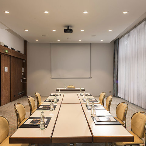 Konferenzraum „Salon Bonn“ im Maritim Seehotel Timmendorfer Strand mit Besprechungstisch,Tageslicht und Präsentationsleinwand