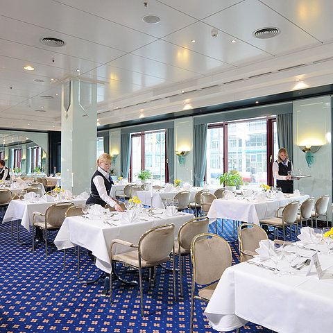 Tagungsraum Salon Bonn im Maritim Hotel Magdeburg mit weiß gedeckten Tischen, eleganter Dekoration und freundlichem Servicepersonal.