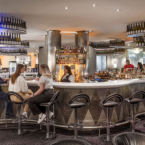 Elegante Bar im Maritim Berlin, in der Gäste entspannte Gespräche genießen und eine große Auswahl an Getränken geboten wird.
