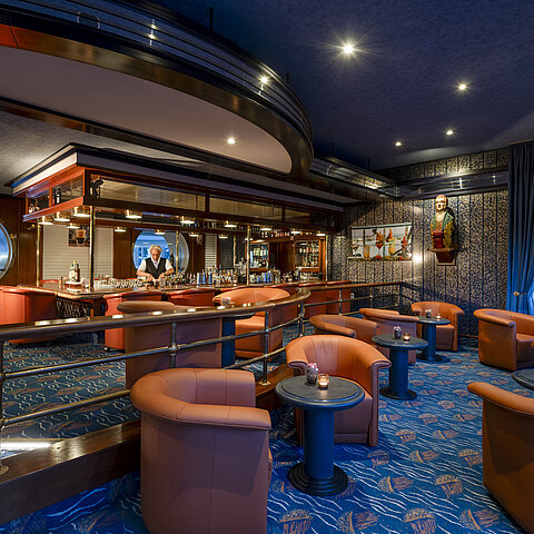Stilvolle Bar mit gemütlichen Sesseln und maritimer Dekoration im Maritim Seehotel Timmendorfer Strand.