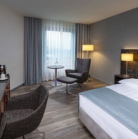 Modern eingerichtetes Superior Smart Zimmer mit Schreibtisch, Fernseher, Sitzbereich und komfortablem Bett im Maritim Bremen.