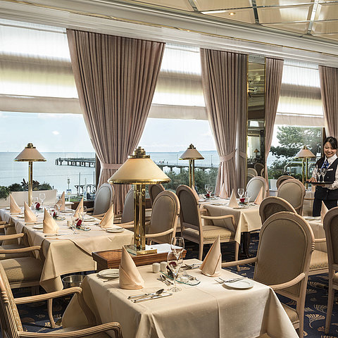 Elegantes Restaurant mit Meerblick und gedeckten Tischen im Maritim Seehotel Timmendorfer Strand.
