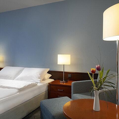 Komfortables Einzelzimmer mit Queensize-Bett, modernen Möbeln und stimmungsvollem Licht im Maritim Hotel Darmstadt.