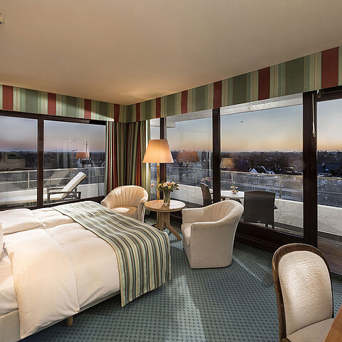 Superior Zimmer im Maritim Seehotel Timmendorfer Strand mit Meerblick, Doppelbett, Sitzecke und Balkon.