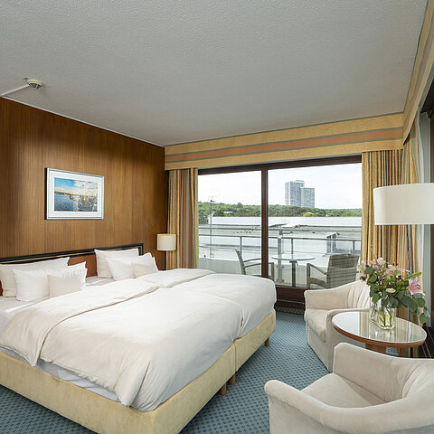 Geräumige Familiensuite im Maritim Seehotel Timmendorfer Strand mit Balkon, Meerblick und gemütlicher Sitzecke.