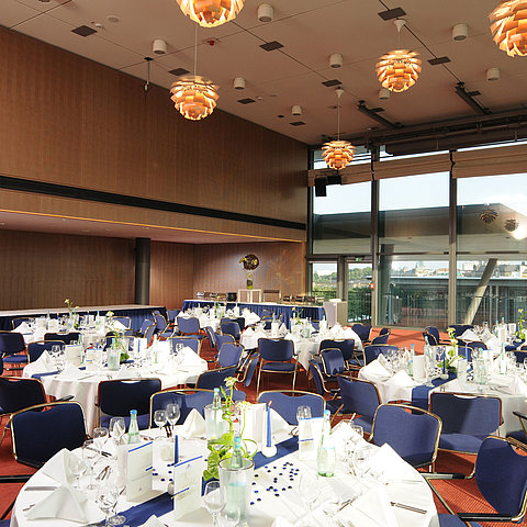 Eleganter Veranstaltungsraum im Maritim Hotel Dresden mit festlich gedeckten Tischen und Blick auf die Stadt.