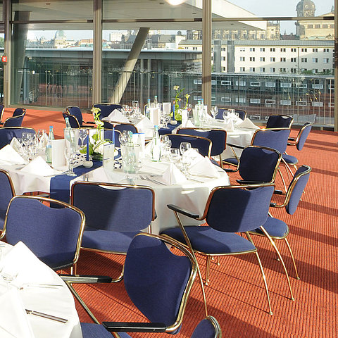  Eleganter Veranstaltungsraum im Maritim Hotel Dresden mit festlich gedeckten Tischen und Blick auf die Stadt.