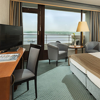 Superior Zimmer im Maritim Hotel Kiel mit Schreibtisch, Sitzbereich, großem Doppelbett und Balkon mit Blick auf die Förde.