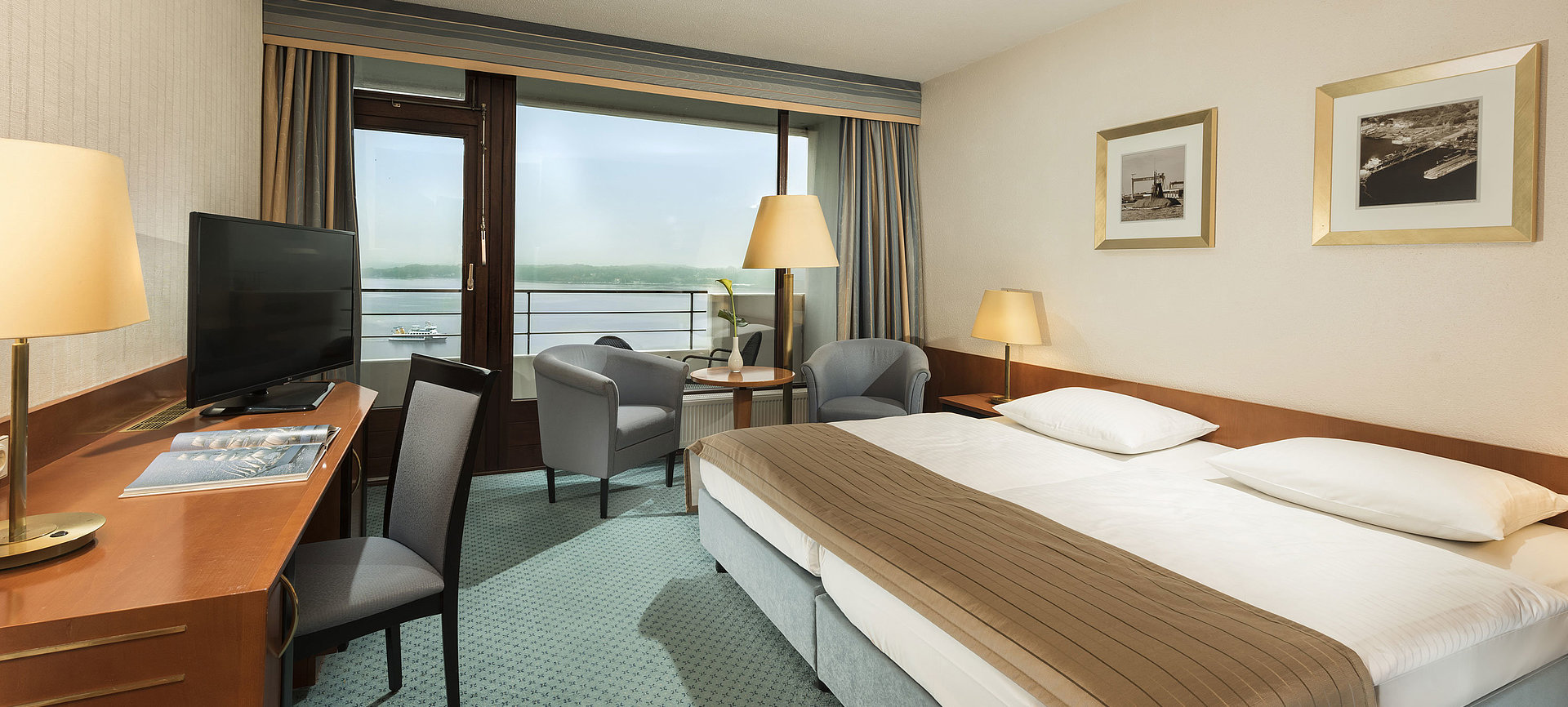 Superior Zimmer im Maritim Hotel Kiel mit Schreibtisch, Sitzbereich, großem Doppelbett und Balkon mit Blick auf die Förde.