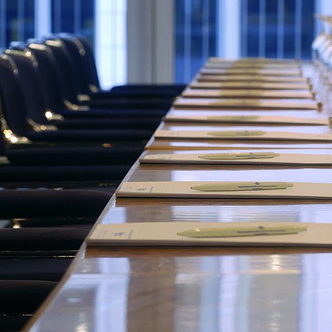 Nahaufnahme eines vorbereiteten Konferenztisches im Maritim proArte Hotel Berlin, mit Notizblöcken und Weingläsern.