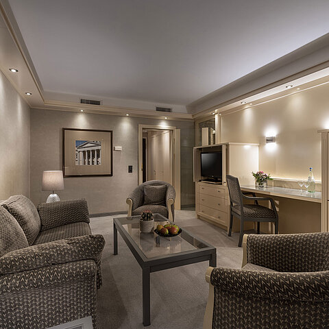 Elegante Suite im Maritim Hotel Darmstadt mit gemütlicher Sitzecke, stilvoller Beleuchtung und Schreibtisch.