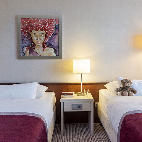 Classic Familienzimmer im Maritim Hotel Bonn mit zwei Betten, Nachttisch und moderner Kunst für einen komfortablen Aufenthalt