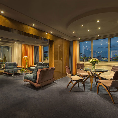 Elegantes Wohnzimmer in der Präsidenten-Suite im Maritim proArte Hotel Berlin mit stilvoller Beleuchtung und Aussicht.