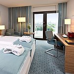 Superior Zimmer im Maritim Hotel Darmstadt mit stilvollem Design, Schreibtisch, Sitzecke und Doppelbett mit Bademänteln.