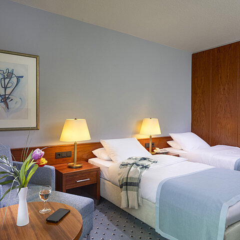Comfort Twin-Zimmer im Maritim Hotel Darmstadt mit zwei Einzelbetten, gemütlicher Sitzecke und eleganter Inneneinrichtung.