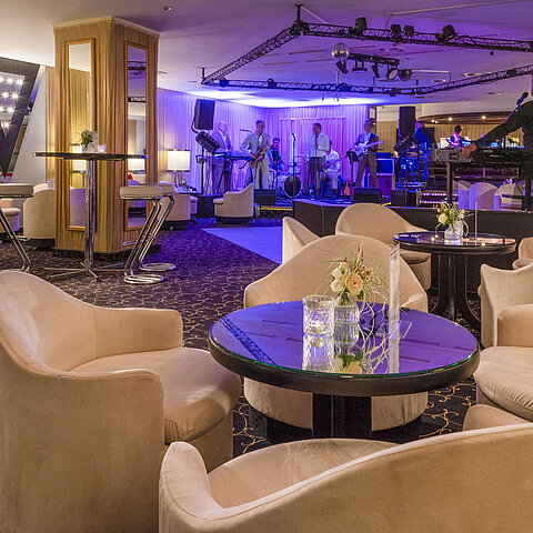 Eleganter Barbereich mit Live-Band, stimmungsvoller Beleuchtung und komfortablen Sitzgelegenheiten für Gäste.