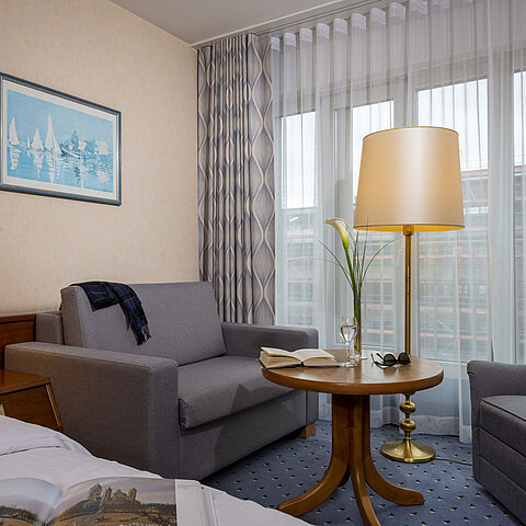Comfort Zimmer im Maritim Hotel Köln, mit gemütlicher Sitzecke, Lesetisch und moderner Einrichtung.