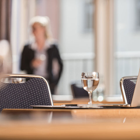  Detailansicht eines Konferenzraums im Maritim proArte Hotel Berlin mit Fokus auf Laptop und Wasserglas.