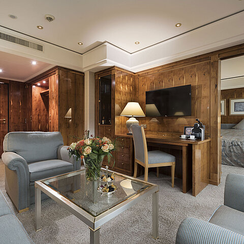 Penthouse-Suite mit Wohnzimmer, Holzmöbeln, Schreibtisch und Blick ins Schlafzimmer im Maritim Seehotel Timmendorfer Strand.