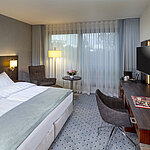 Modernes Superior-Doppelzimmer im Maritim Bremen mit Sitzbereich, Schreibtisch und großem Fenster für natürliche Beleuchtung.