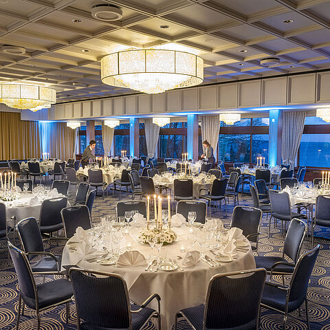 Saal Maritim im Maritim Hotel Kiel, festlich gedeckte Tische mit Kerzenlicht, elegantes Ambiente, Personal bereitet die Veranstaltung vor.
