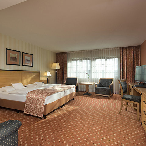 Classic Zimmer im Maritim Hotel Dresden mit Doppelbett, Sitzbereich und klassischem Dekor.