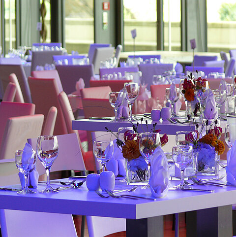 Detailansicht von elegant gedeckten Tischen mit Blumenarrangements im Veranstaltungsraum des Maritim Hotel Dresden.
