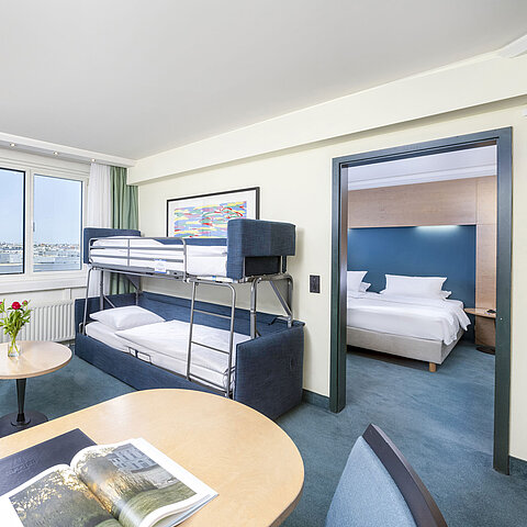 Moderne Familiensuite im Maritim proArte Hotel Berlin mit Etagenbett, Sitzecke und separatem Schlafzimmer.