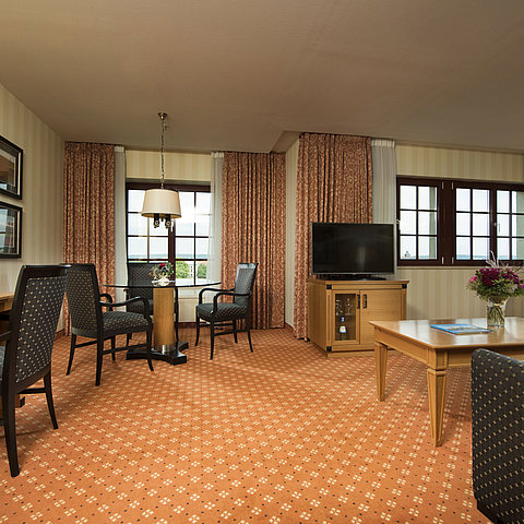 Junior Suite im Maritim Hotel Dresden mit stilvoller Sitzecke, großem Schreibtisch und moderner Einrichtung.