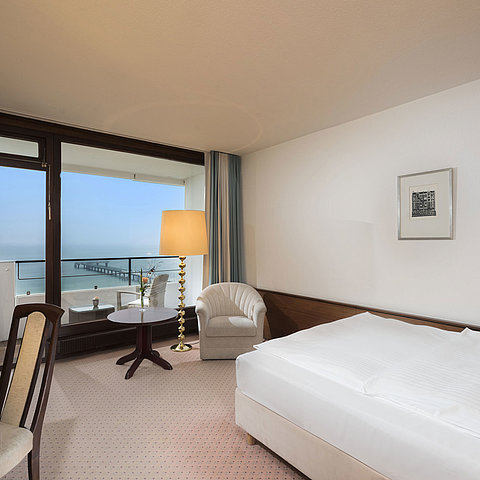Superior Einzelzimmer im Maritim Seehotel Timmendorfer Strand mit Meerblick, Balkon und gemütlicher Sitzecke.